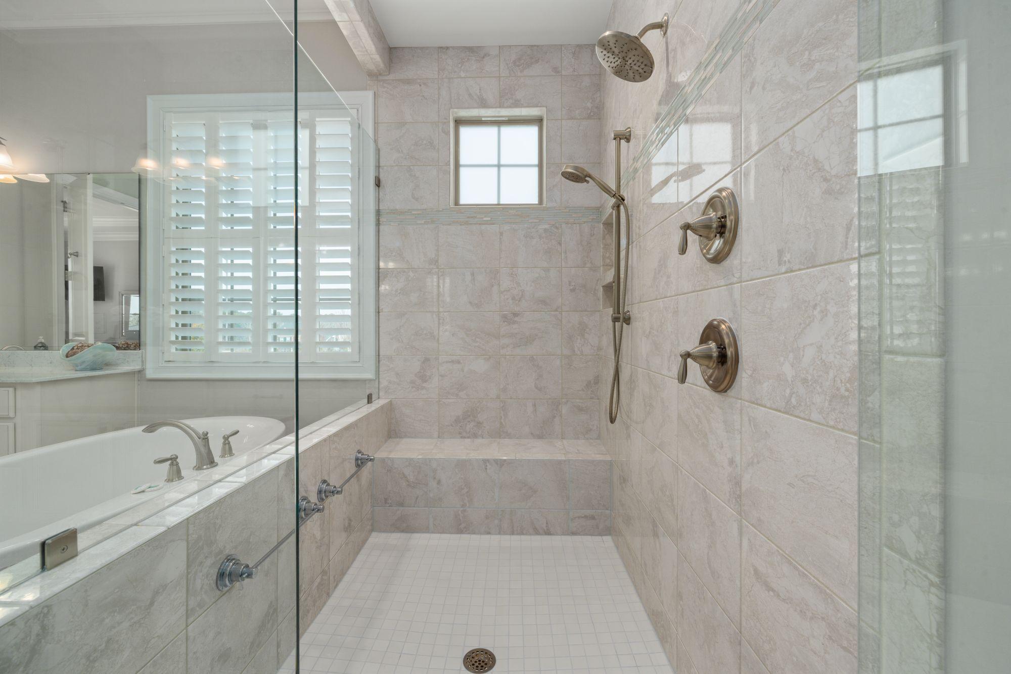 Tiled shower and glass enclosure in a bright bathroom